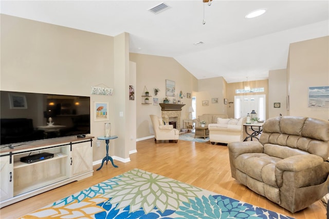 11148 Hollander Ave, Hudson, FL 34667 - living room with light wood-type flooring, vaulted ceiling, a fireplace, a chandelier, and baseboards
