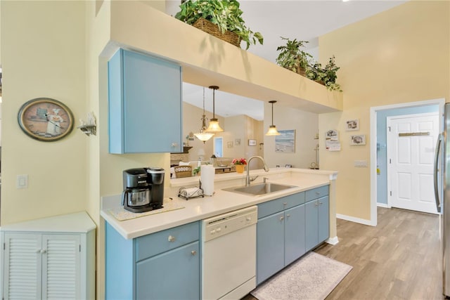 11148 Hollander Ave, Hudson, FL 34667 - kitchen featuring white dishwasher, blue cabinetry, a sink, decorative light fixtures, and light wood-style flooring