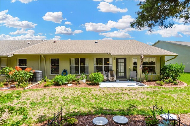 11148 Hollander Ave, Hudson, FL 34667 - rear view of house featuring a shingled roof, central AC unit, a yard, and stucco siding