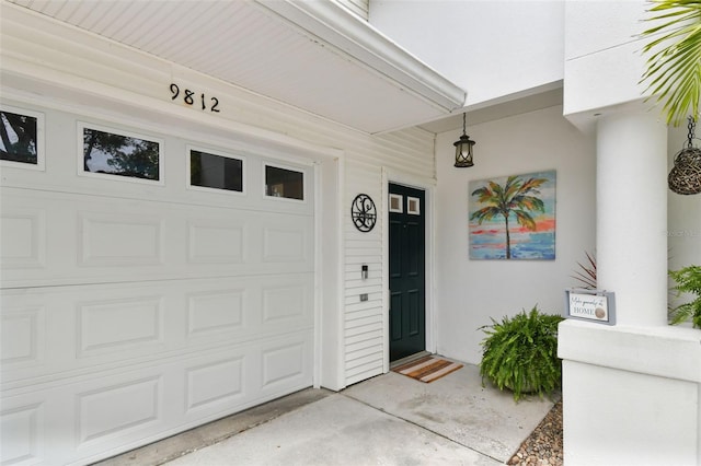 9812 Indian Key Trl Unit 84, Seminole, FL 33776 - property entrance featuring a garage and stucco siding