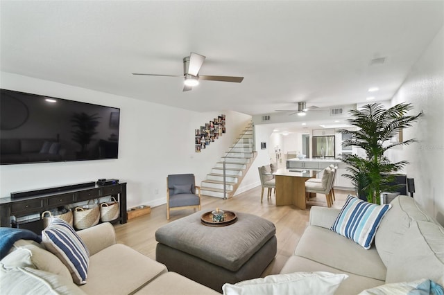 9812 Indian Key Trl Unit 84, Seminole, FL 33776 - living area featuring ceiling fan, stairs, light wood-type flooring, and baseboards