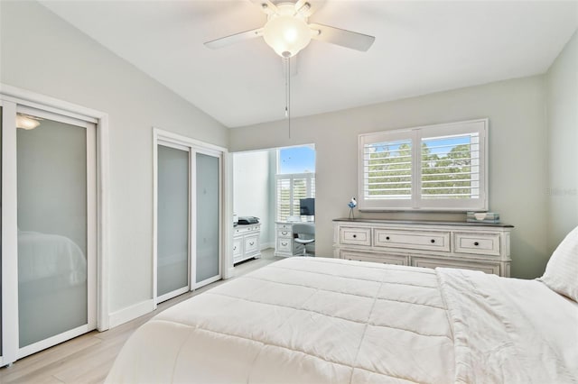 9812 Indian Key Trl Unit 84, Seminole, FL 33776 - bedroom with light wood-type flooring, vaulted ceiling, ceiling fan, two closets, and baseboards