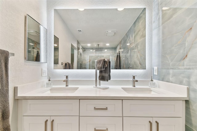9812 Indian Key Trl Unit 84, Seminole, FL 33776 - bathroom featuring double vanity, a textured wall, and a stall shower