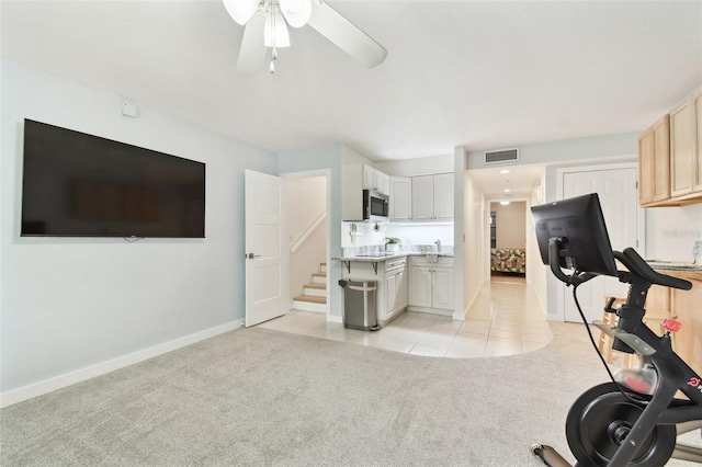 9812 Indian Key Trl Unit 84, Seminole, FL 33776 - exercise area featuring light carpet, ceiling fan, baseboards, light tile patterned floors, and a sink