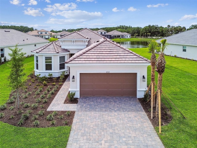 4709 Isonzo Way, Wesley Chapel, FL 33543 - view of front of property with a front yard, an attached garage, stucco siding, and decorative driveway