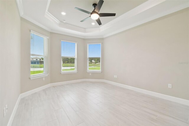 4709 Isonzo Way, Wesley Chapel, FL 33543 - unfurnished room with ornamental molding, a raised ceiling, a ceiling fan, baseboards, and light wood-style flooring