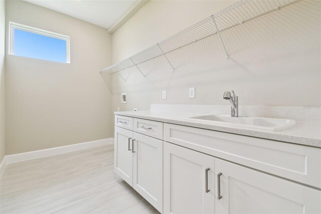 4709 Isonzo Way, Wesley Chapel, FL 33543 - laundry room with washer hookup, baseboards, and light wood-type flooring