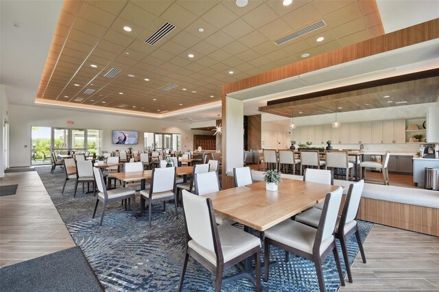 4709 Isonzo Way, Wesley Chapel, FL 33543 - dining area featuring light wood-style flooring, a tray ceiling, and a paneled ceiling