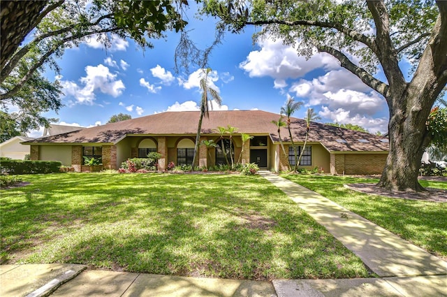 17917 Clear Lake Dr, Lutz, FL 33548 - ranch-style house featuring a front lawn and brick siding