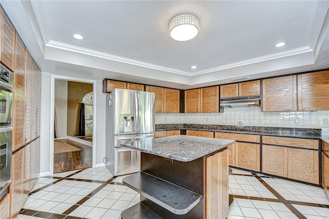17917 Clear Lake Dr, Lutz, FL 33548 - kitchen featuring stainless steel fridge with ice dispenser, inlaid floor details, under cabinet range hood, a raised ceiling, and light tile patterned floors
