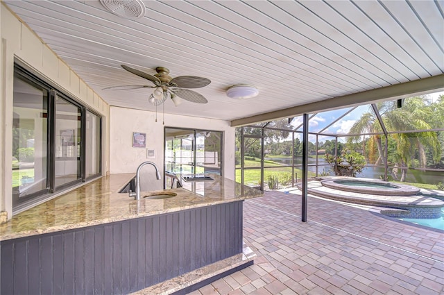 17917 Clear Lake Dr, Lutz, FL 33548 - unfurnished sunroom with a sink, a hot tub, a water view, and ceiling fan