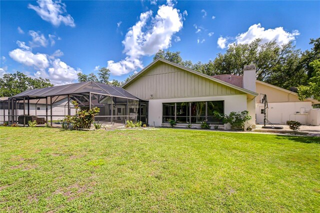 17917 Clear Lake Dr, Lutz, FL 33548 - back of property with a chimney, a lawn, and glass enclosure