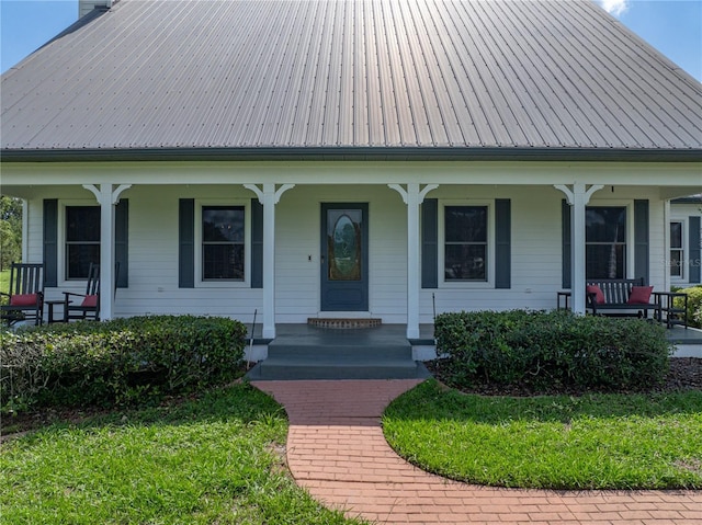 16326 Kalli Way, Dade City, FL 33523 - view of front facade featuring covered porch, a chimney, and metal roof