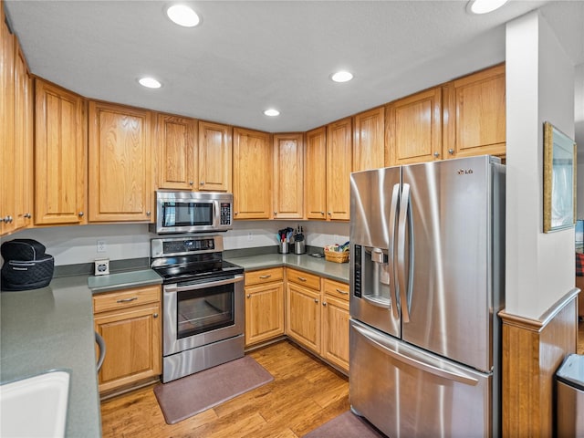 16326 Kalli Way, Dade City, FL 33523 - kitchen with appliances with stainless steel finishes, light wood-type flooring, recessed lighting, and a sink