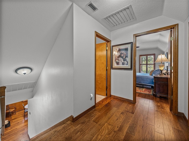 16326 Kalli Way, Dade City, FL 33523 - corridor with wood-type flooring, baseboards, a textured ceiling, and vaulted ceiling