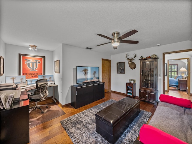 16326 Kalli Way, Dade City, FL 33523 - living room featuring an office area, ceiling fan, wood finished floors, baseboards, and a textured ceiling
