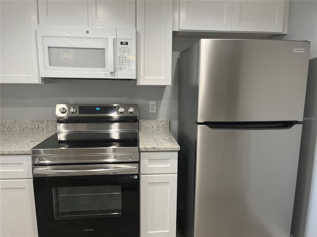 4008 Ashford Green Pl Unit F101, Tampa, FL 33613 - kitchen with stainless steel appliances, white cabinets, and light stone countertops