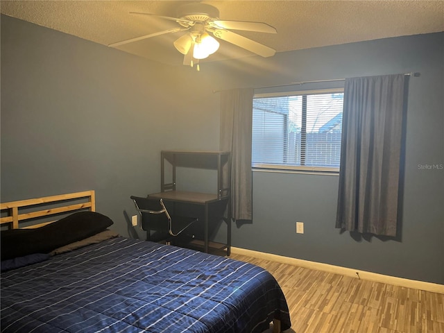4008 Ashford Green Pl Unit F101, Tampa, FL 33613 - bedroom with wood finished floors, baseboards, a ceiling fan, and a textured ceiling