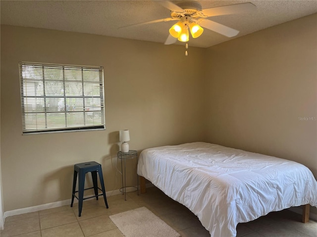 4008 Ashford Green Pl Unit F101, Tampa, FL 33613 - bedroom featuring light tile patterned floors, ceiling fan, a textured ceiling, and baseboards