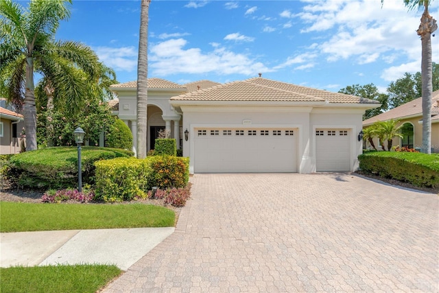 13872 Siena Loop, Lakewood Ranch, FL 34202 - mediterranean / spanish house with decorative driveway, an attached garage, a tiled roof, and stucco siding