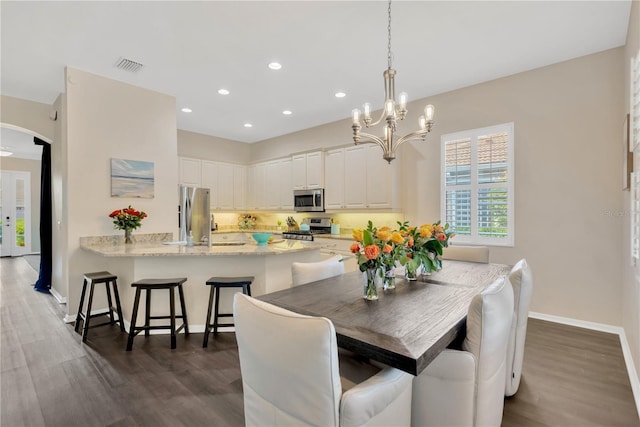 13872 Siena Loop, Lakewood Ranch, FL 34202 - dining room featuring arched walkways, dark wood-style flooring, a chandelier, baseboards, and recessed lighting