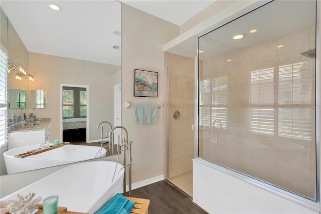 13872 Siena Loop, Lakewood Ranch, FL 34202 - bathroom with a freestanding bath, a walk in shower, ensuite bath, wood finished floors, and vanity