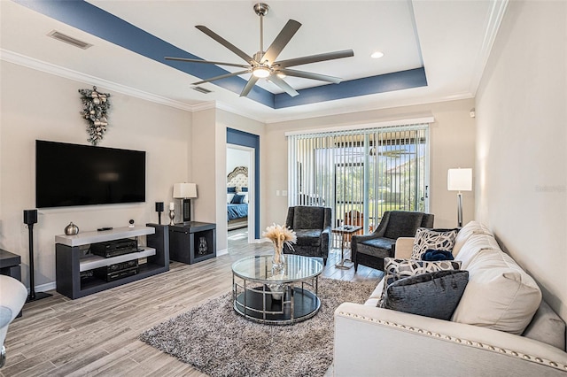 2515 63rd Ter E, Ellenton, FL 34222 - living room featuring a tray ceiling, wood finished floors, ceiling fan, ornamental molding, and baseboards