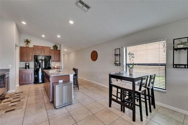 11121 Hudson Hills Ln, Riverview, FL 33579 - kitchen with black refrigerator with ice dispenser, a sink, a kitchen island with sink, recessed lighting, and baseboards