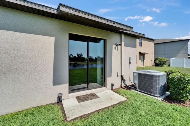 11121 Hudson Hills Ln, Riverview, FL 33579 - property entrance featuring stucco siding, central air condition unit, and a water view