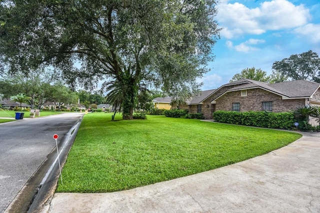 24 Lake Vista Way, Ormond Beach, FL 32174 - view of side of home with a yard, a shingled roof, and brick siding