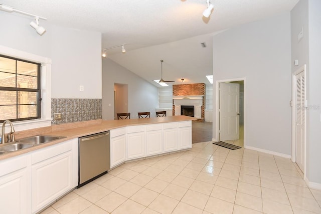 24 Lake Vista Way, Ormond Beach, FL 32174 - kitchen featuring rail lighting, stainless steel dishwasher, a fireplace, high vaulted ceiling, and open floor plan
