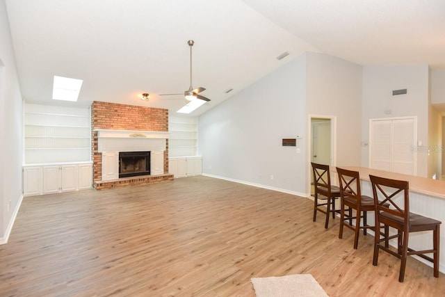 24 Lake Vista Way, Ormond Beach, FL 32174 - living room featuring a ceiling fan, light wood finished floors, a skylight, baseboards, and lofted ceiling
