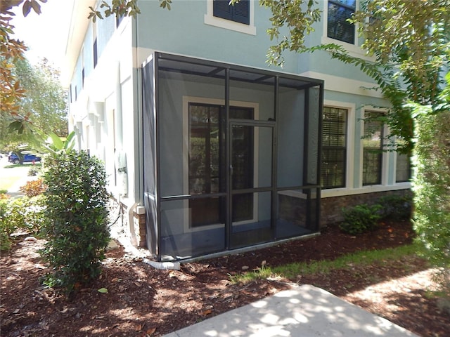 16618 Kingletside Ct, Lithia, FL 33547 - view of home's exterior featuring stucco siding, stone siding, and a sunroom