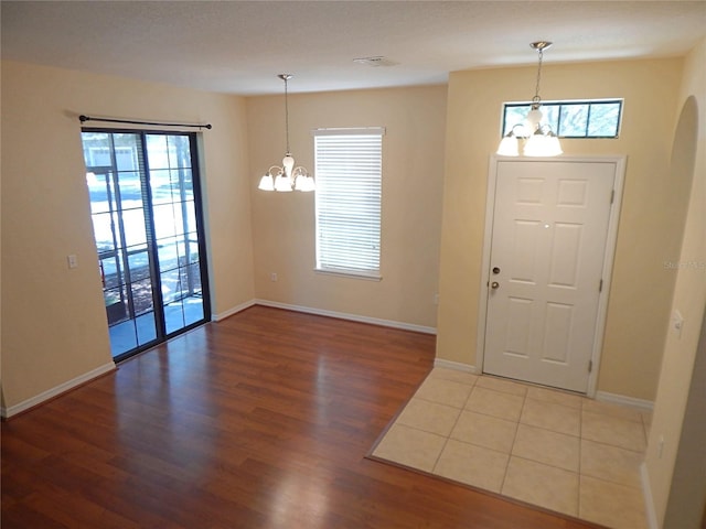 16618 Kingletside Ct, Lithia, FL 33547 - entrance foyer featuring a chandelier, wood finished floors, baseboards, and arched walkways