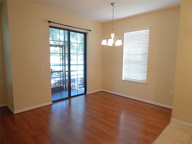 16618 Kingletside Ct, Lithia, FL 33547 - unfurnished room featuring a chandelier, wood finished floors, and baseboards