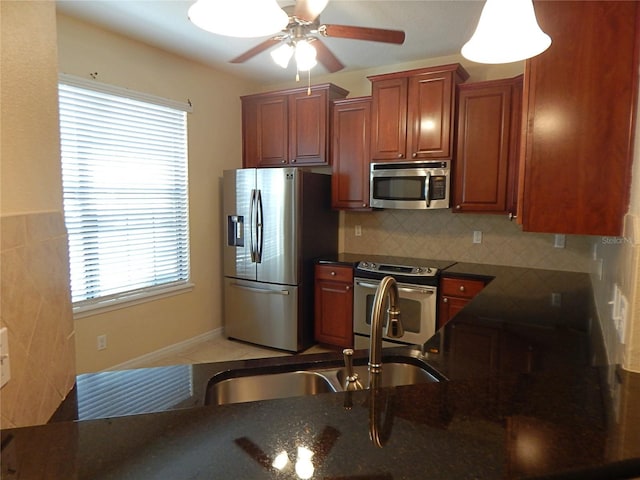16618 Kingletside Ct, Lithia, FL 33547 - kitchen with appliances with stainless steel finishes, ceiling fan, plenty of natural light, and dark stone counters