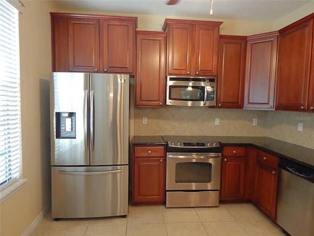 16618 Kingletside Ct, Lithia, FL 33547 - kitchen with appliances with stainless steel finishes, dark countertops, tasteful backsplash, and light tile patterned floors