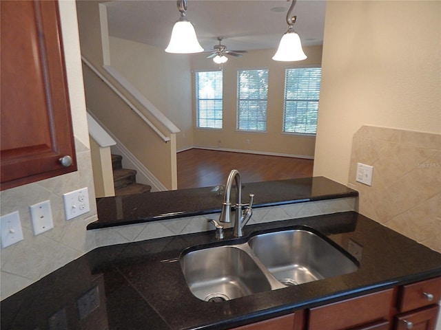 16618 Kingletside Ct, Lithia, FL 33547 - kitchen featuring a sink, decorative backsplash, dark countertops, ceiling fan, and hanging light fixtures