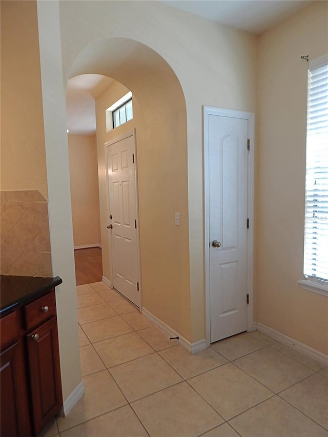 16618 Kingletside Ct, Lithia, FL 33547 - hallway featuring arched walkways, light tile patterned floors, and baseboards