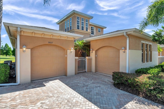 2407 Kensington Greens Dr, Sun City Center, FL 33573 - view of front of home featuring stucco siding, decorative driveway, a garage, and a gate