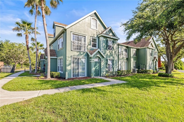 9416 Lake Chase Island Way Unit 9416, Tampa, FL 33626 - view of front of house featuring stucco siding, a front yard, and central air condition unit