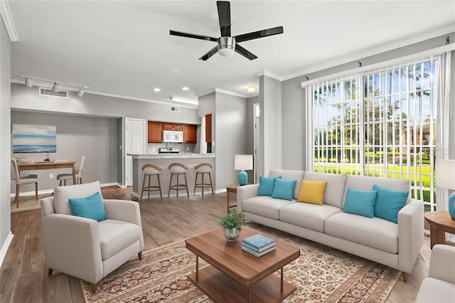 9416 Lake Chase Island Way Unit 9416, Tampa, FL 33626 - living area featuring ornamental molding, a ceiling fan, light wood finished floors, baseboards, and recessed lighting