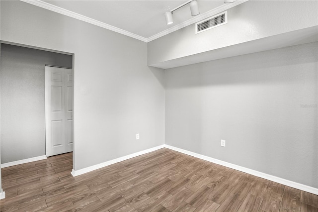9416 Lake Chase Island Way Unit 9416, Tampa, FL 33626 - spare room featuring ornamental molding, wood finished floors, baseboards, and track lighting