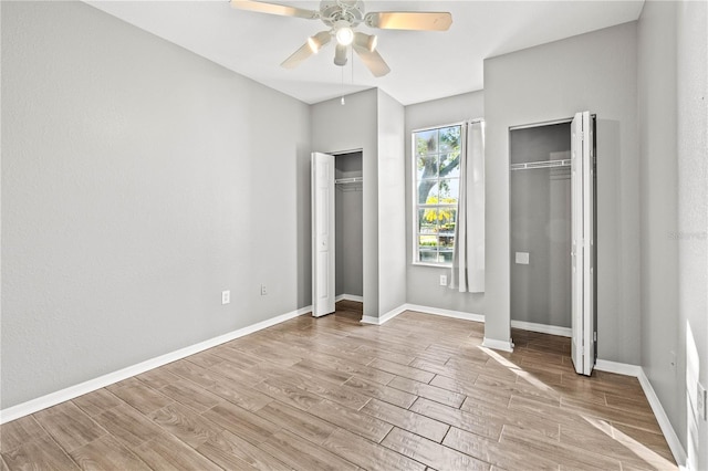 9416 Lake Chase Island Way Unit 9416, Tampa, FL 33626 - unfurnished bedroom featuring multiple closets, wood finished floors, baseboards, and a ceiling fan