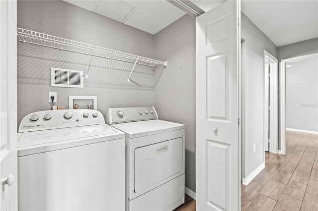 9416 Lake Chase Island Way Unit 9416, Tampa, FL 33626 - washroom with independent washer and dryer, light wood-style flooring, and baseboards