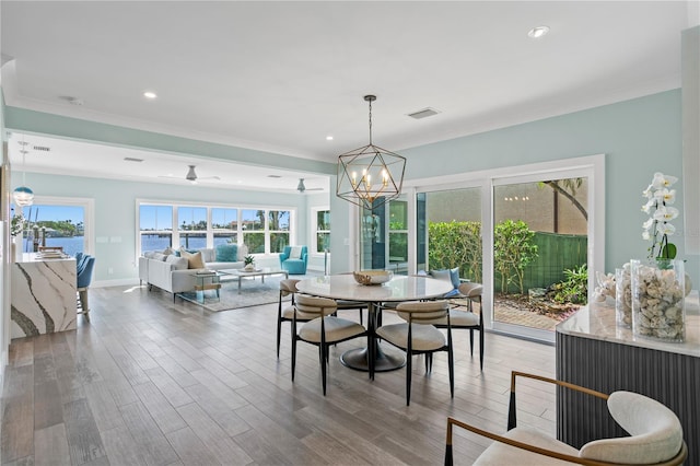 2903 Pass A Grille Way, St Pete Beach, FL 33706 - dining room featuring a chandelier, crown molding, wood finished floors, a water view, and recessed lighting