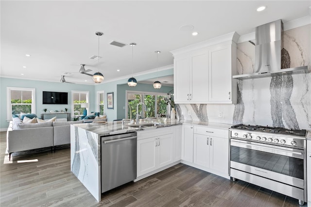 2903 Pass A Grille Way, St Pete Beach, FL 33706 - kitchen with wall chimney exhaust hood, stainless steel appliances, a sink, recessed lighting, and light stone counters