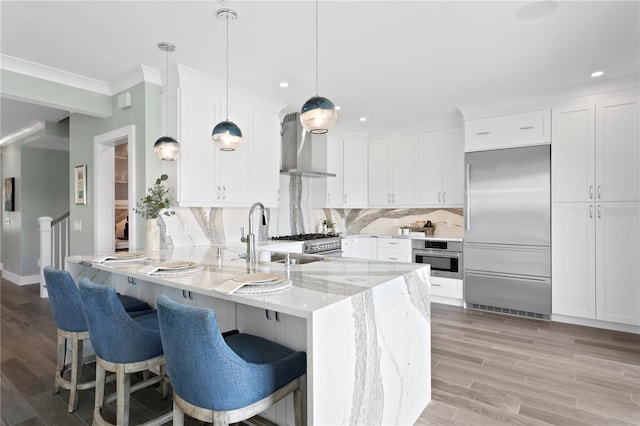 2903 Pass A Grille Way, St Pete Beach, FL 33706 - kitchen with stainless steel appliances, wall chimney exhaust hood, a sink, a peninsula, and white cabinetry