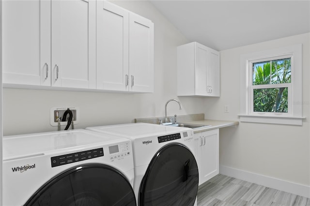 2903 Pass A Grille Way, St Pete Beach, FL 33706 - washroom with cabinet space, washing machine and dryer, baseboards, and light wood-style flooring