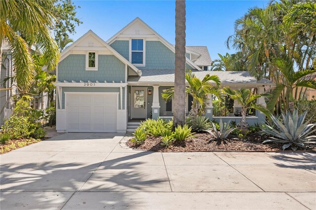 2903 Pass A Grille Way, St Pete Beach, FL 33706 - view of front of house with concrete driveway, a porch, roof with shingles, and an attached garage